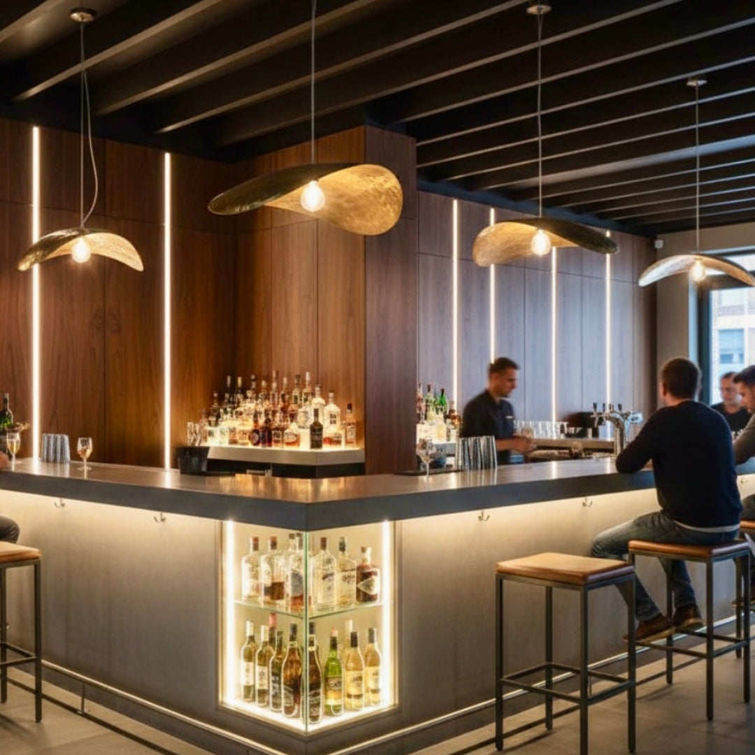 Handcrafted gold Moroccan brass ceiling lights installed above a modern bar counter, highlighting the hammered texture and artisanal craftsmanship.