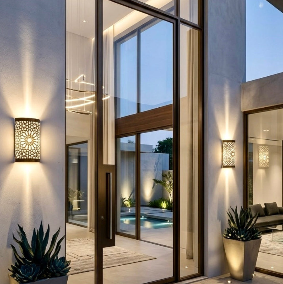 Modern luxury home exterior featuring multiple Moroccan brass wall lamps installed on large pillars overlooking a pool area.