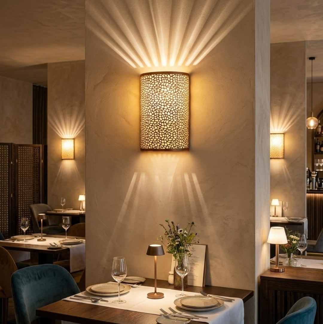 Multiple Moroccan brass wall lights installed in a high-end restaurant dining area, creating a warm boho-chic atmosphere.