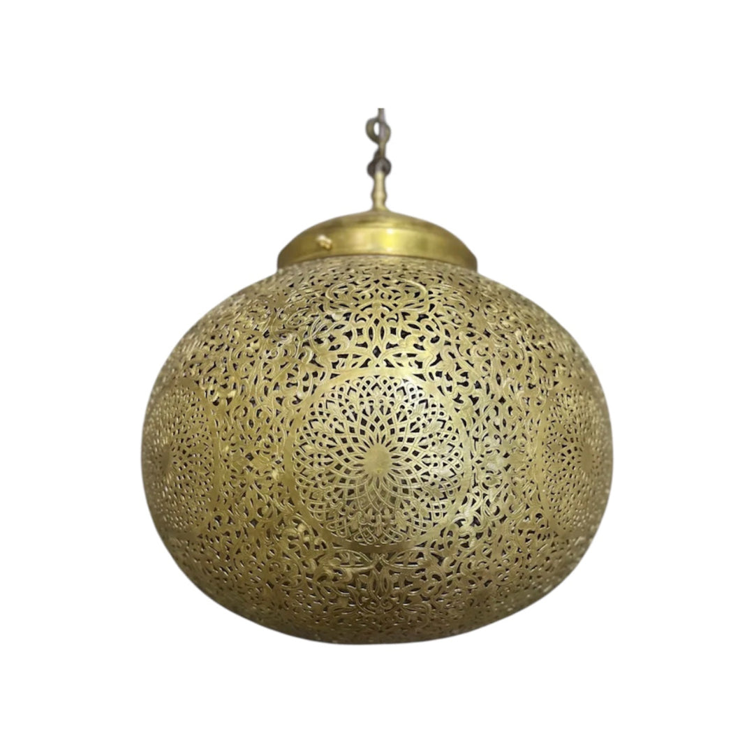 Oversized Moroccan brass filigree lamp hanging in a grand, classical hallway with ornate wall decor.