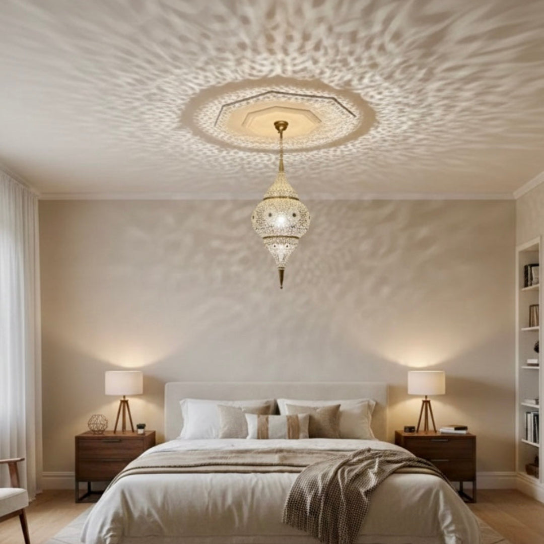 Modern minimalist bedroom decorated with a large Moroccan brass pendant light creating a starburst shadow effect.