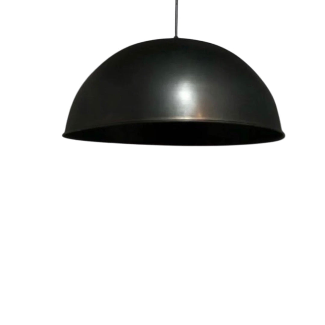 Three graduated black brass dome pendant lights in a minimalist office reception with marble desk and soft lighting.