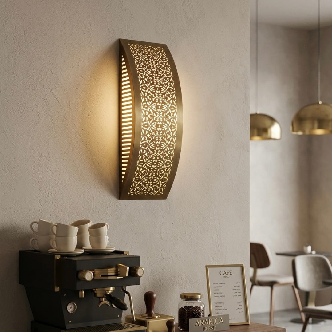 Modern boho-chic cafe interior decorated with a curved Moroccan brass wall lamp creating a shadow play effect.