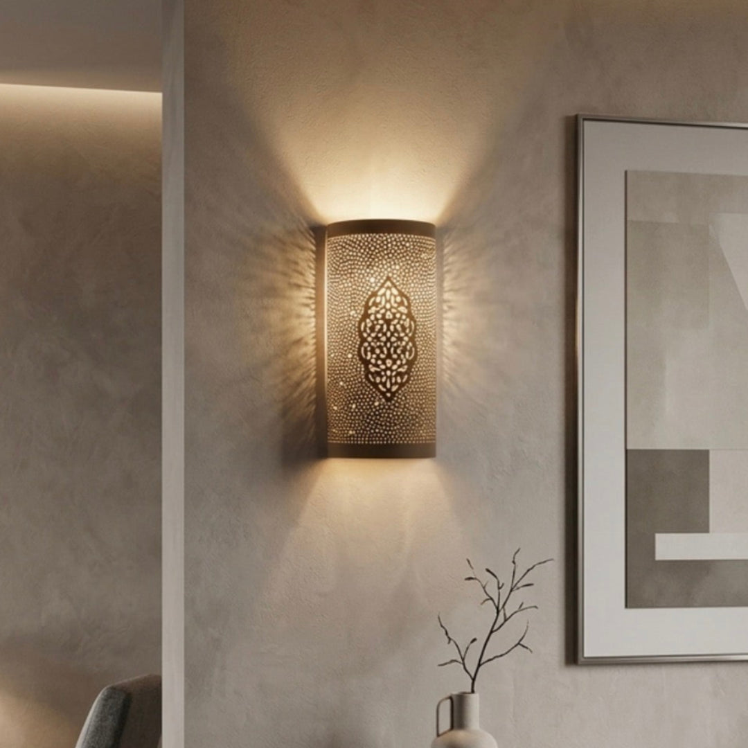 Modern minimalist living room featuring a Moroccan brass wall lamp creating a beautiful light pattern on a grey wall.