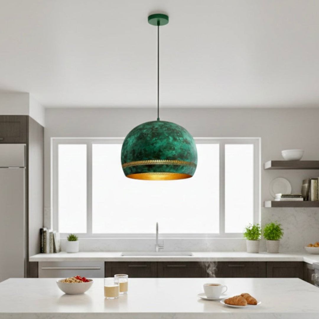 A single handmade Moroccan patina green dome lamp with gold interior hanging over a modern white kitchen island.