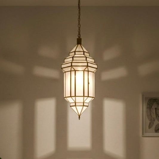 Elegant brass and glass Moroccan lantern hanging in a modern minimalist interior space.