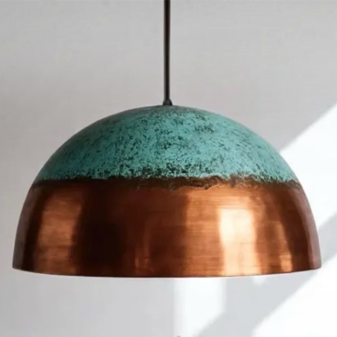 Front view studio detail of a modern Moroccan brass dome pendant light featuring a two-tone copper and turquoise patina finish