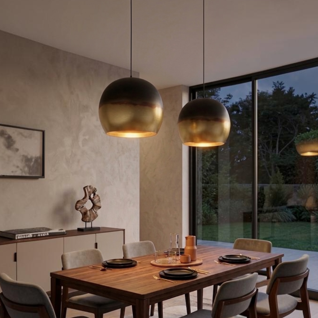  Pair of modern Moroccan handmade brass dome pendant lights hanging above a wooden dining table in a contemporary home interior