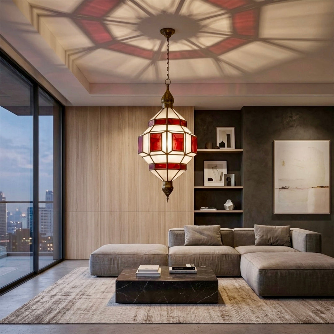 Handmade Moroccan brass chandelier with red glass panels casting geometric shadows on a living room ceiling⁠