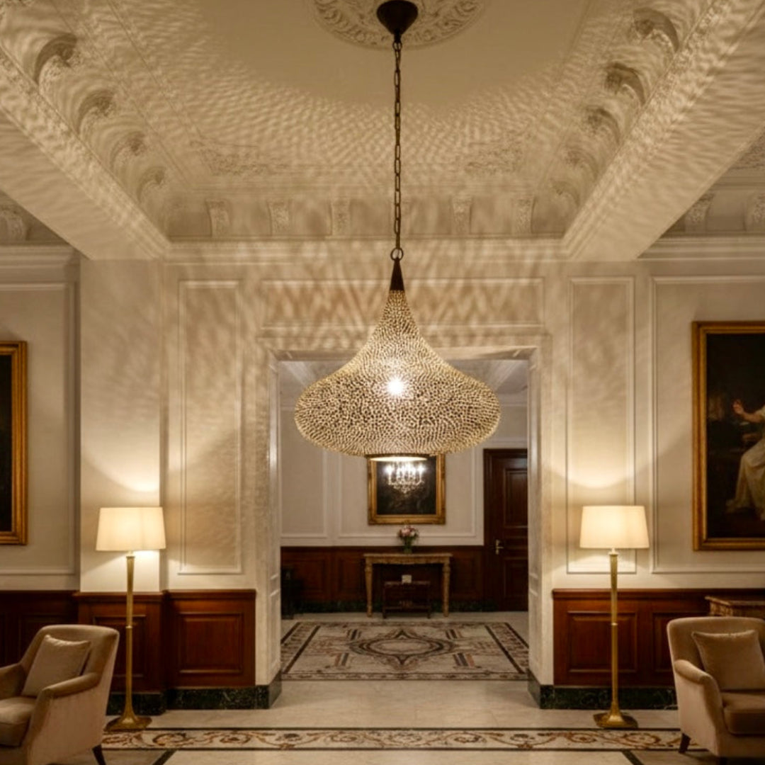 Hand-engraved Moroccan brass pendant lamp casting intricate shadow patterns on a restaurant wall, modern dining room lighting.