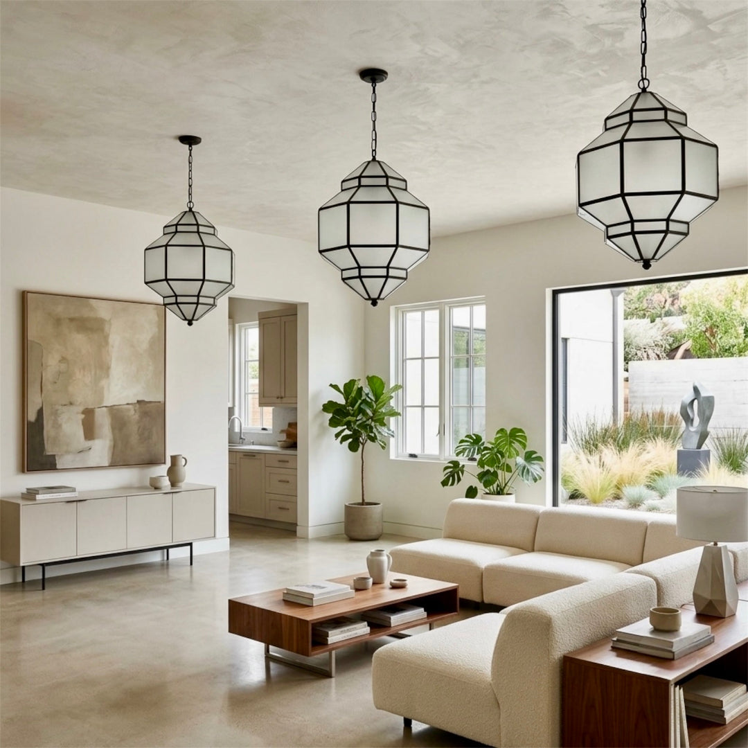 Three modern brass and glass Moroccan pendant lights hanging in a spacious contemporary living room.⁠