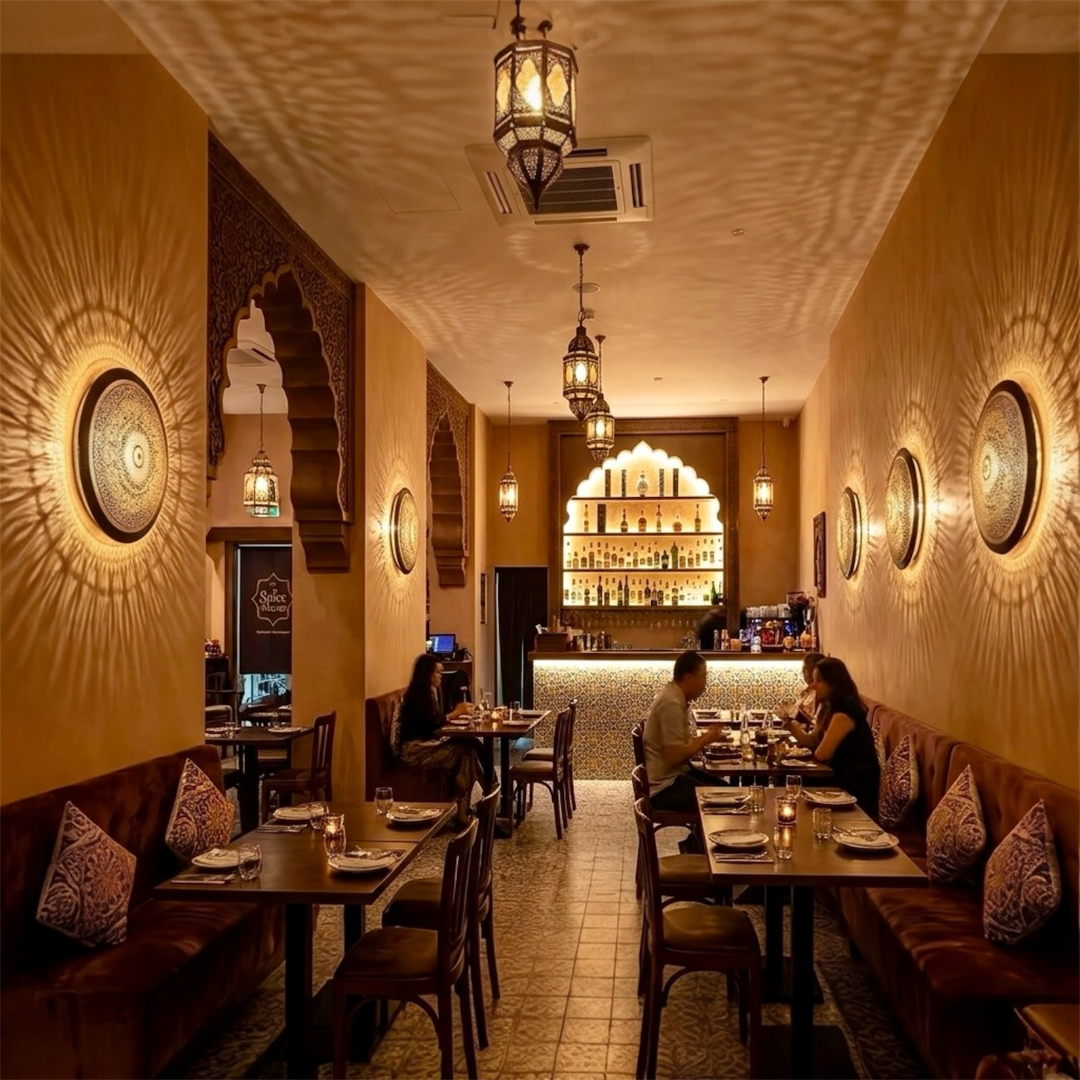 Elegant interior of a modern restaurant illuminated by multiple Moroccan flush mount brass lamps creating warm atmosphere on the walls.