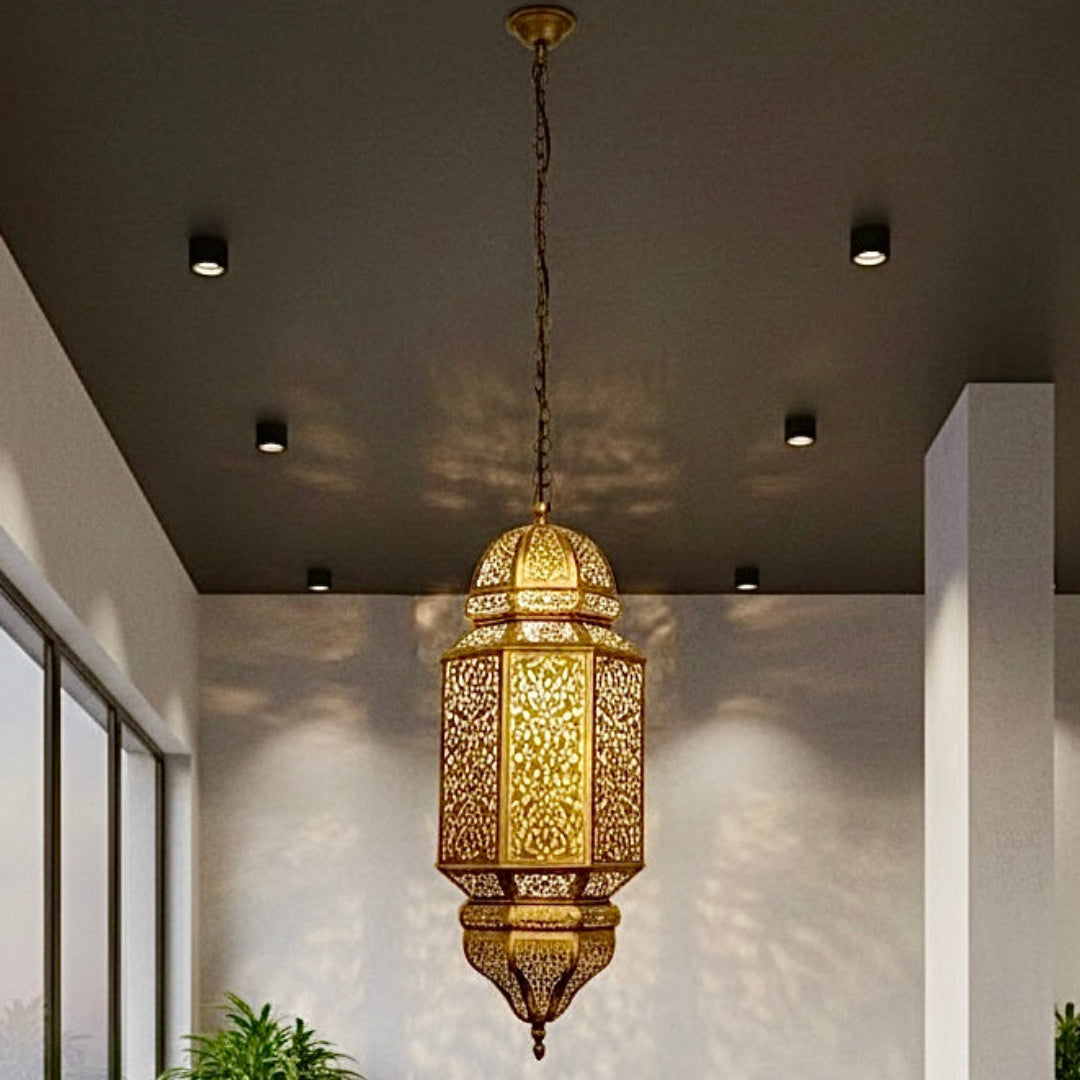 A modern restaurant interior featuring an elegant, handcrafted brass Moroccan pendant lamp casting decorative shadows over dining tables.