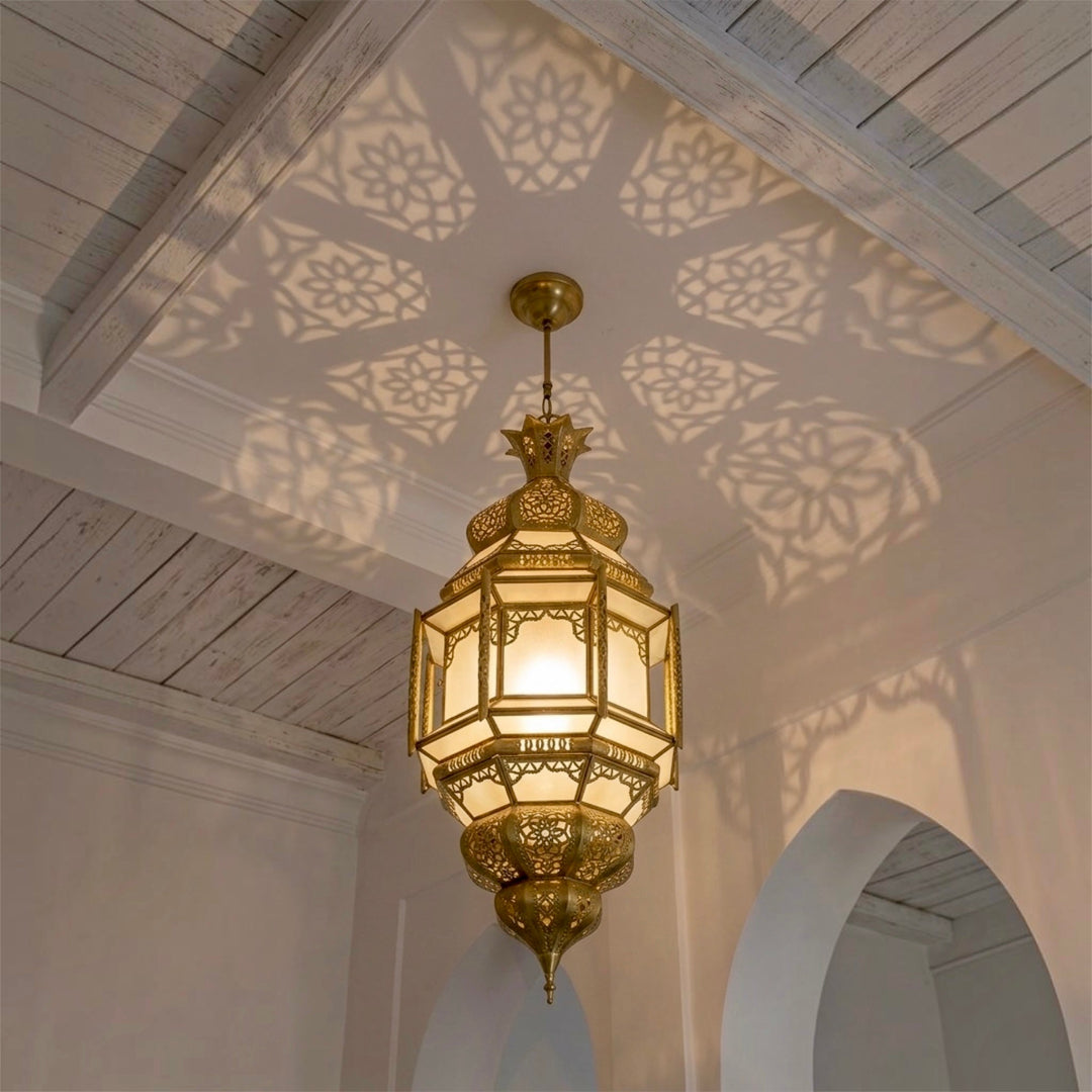Handmade Moroccan brass ceiling light casting intricate geometric shadow patterns on a white wooden ceiling⁠