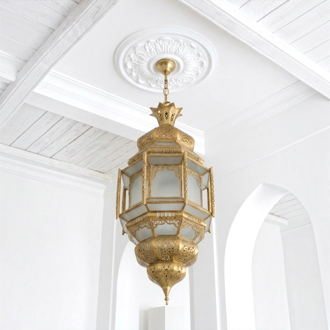 ⁠Close-up of a handcrafted Moroccan brass ceiling light showing unlit frosted glass panels and hand-punched detailing⁠