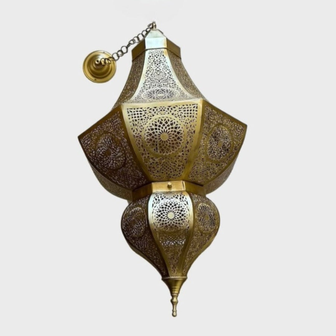  Intricately designed Moroccan brass lamp hanging above a modern freestanding bathtub in a minimalist concrete-finish bathroom.