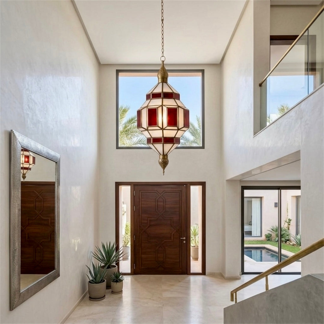 ⁠Handcrafted Moroccan brass pendant light with red stained glass installed in a luxury grand entryway⁠
