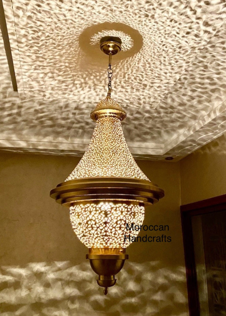  Intricate Moroccan brass pendant lamp casting a decorative shadow pattern across a white ceiling.