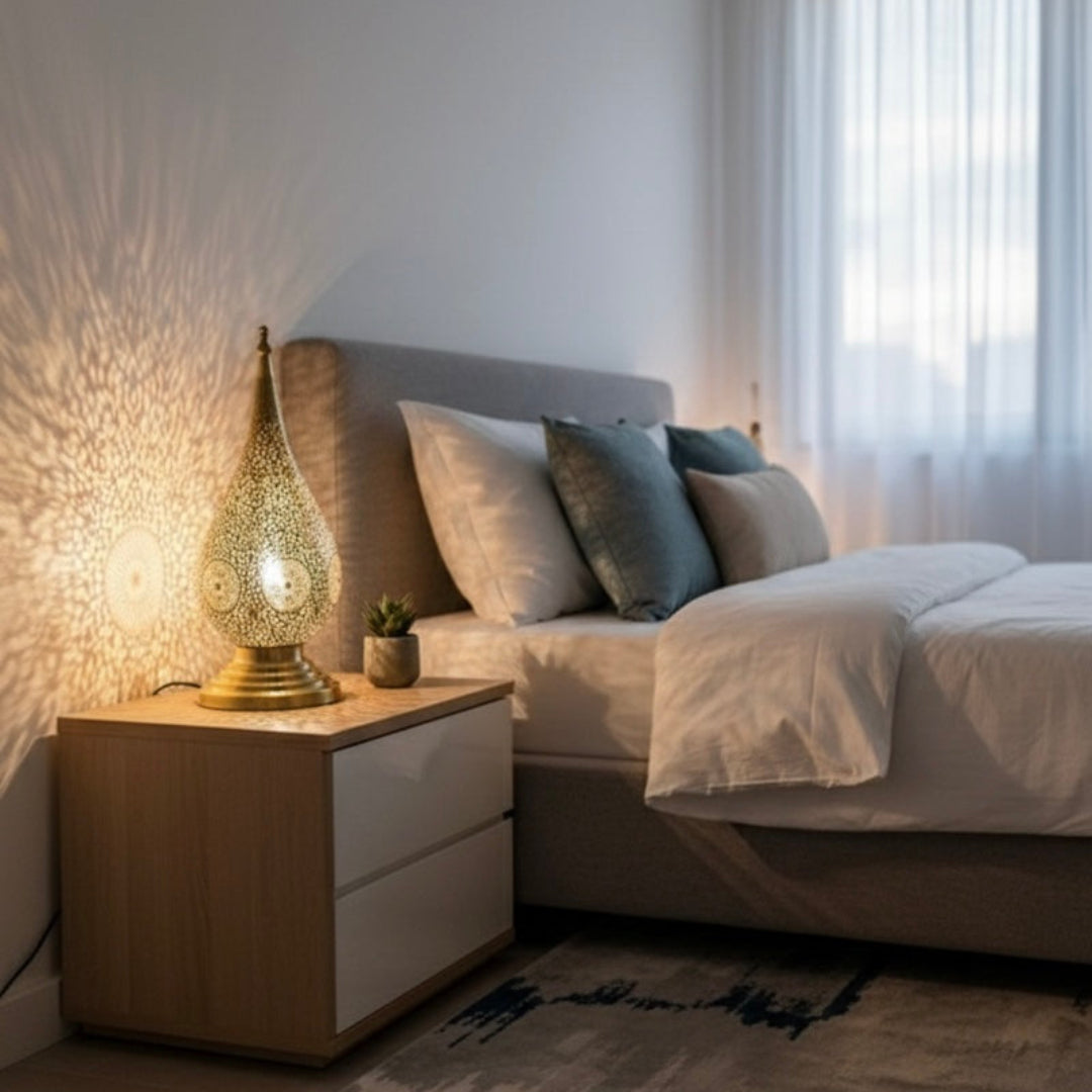 Moroccan brass bedside lamp providing cozy ambient lighting in a minimalist white bedroom.
