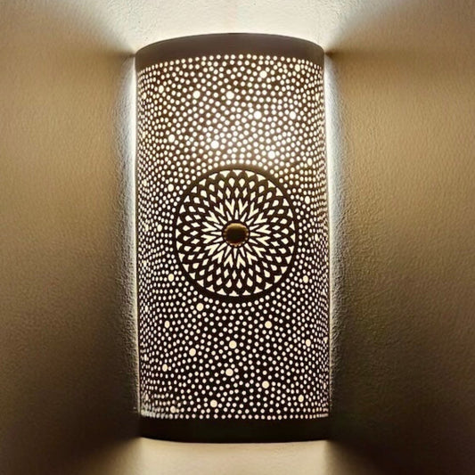  A row of cylinder-shaped Moroccan brass wall lamps casting intricate shadow patterns in a traditional warm-toned restaurant hallway.