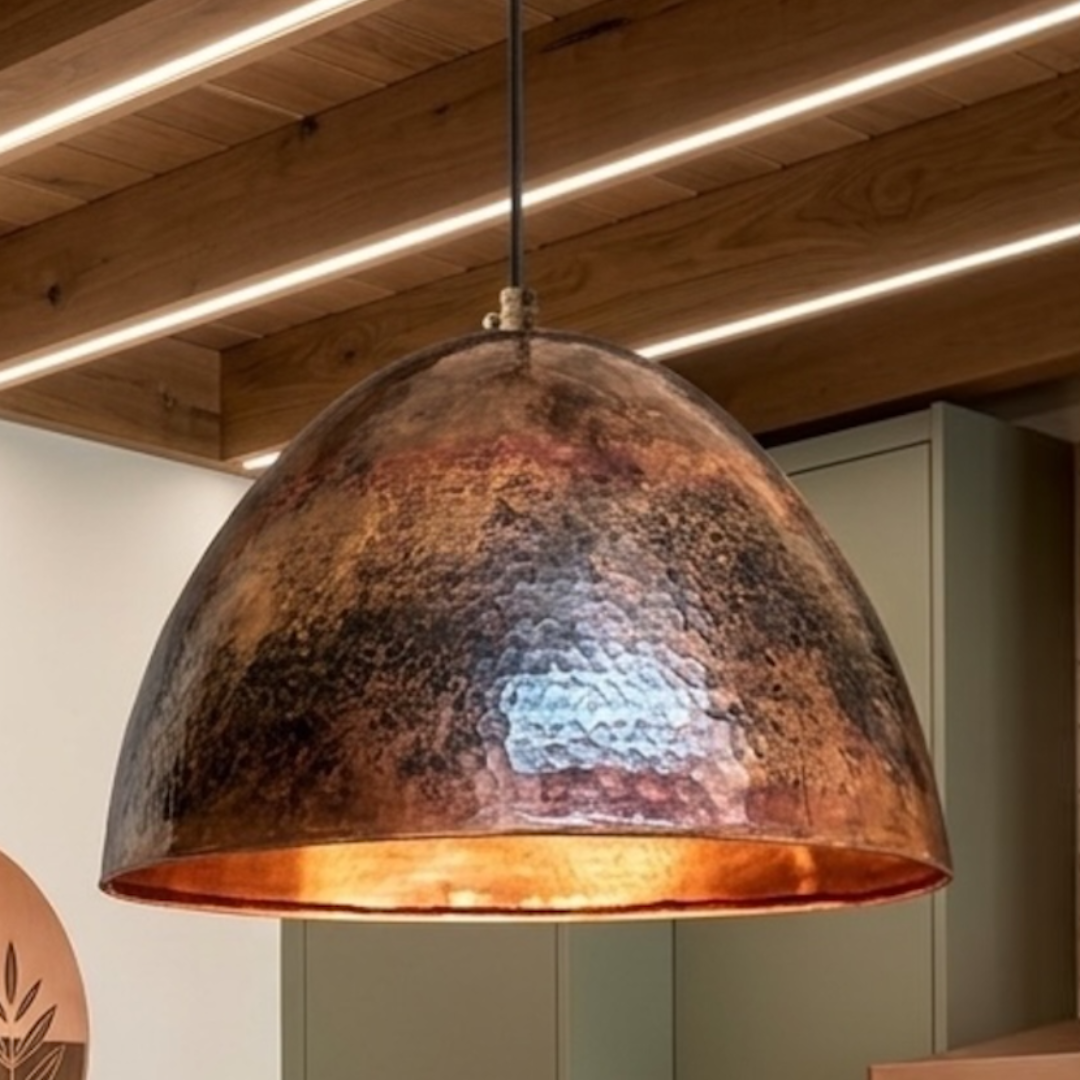  Single modern Moroccan copper dome light fixture showcasing detailed hammered brass craft and warm reddish patina over a kitchen counter
