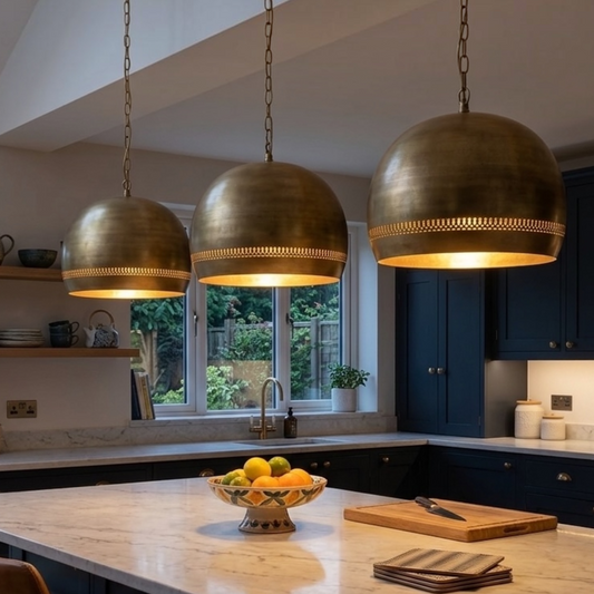  Trio of handmade Moroccan modern brass dome pendant lights hanging above a kitchen island with warm ambient lighting
