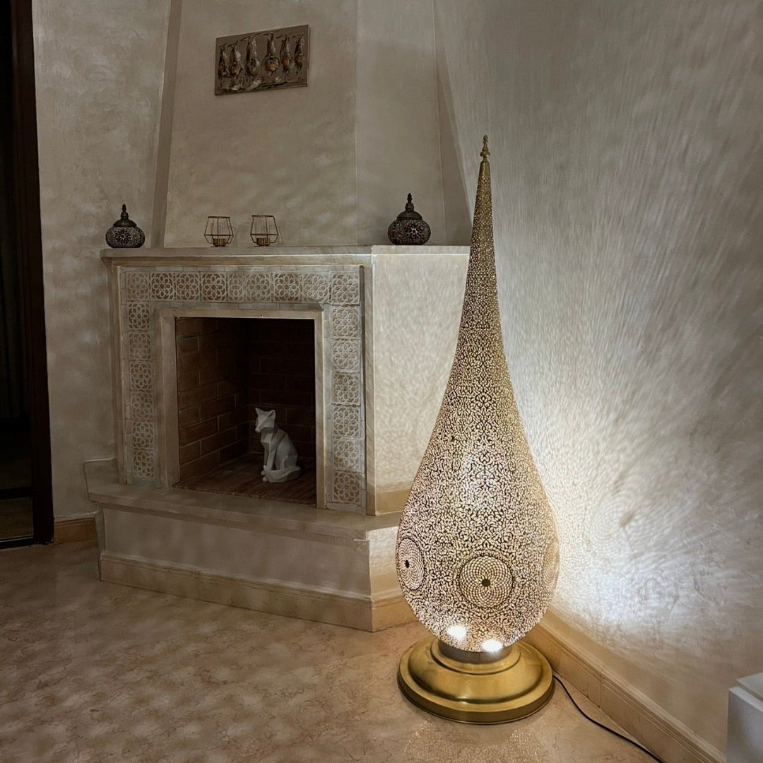  Pair of large Moroccan brass floor lamps flanking a traditional wooden arched doorway, creating a luxurious entryway ambiance.