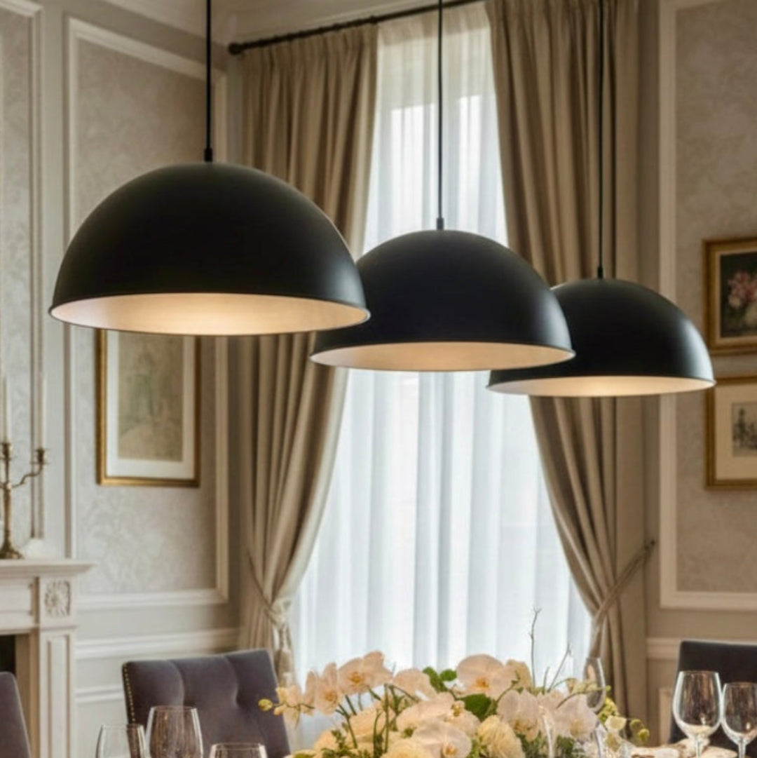 Trio of black brass Moroccan dome lamps installed over a classic wooden dining table with elegant table setting.