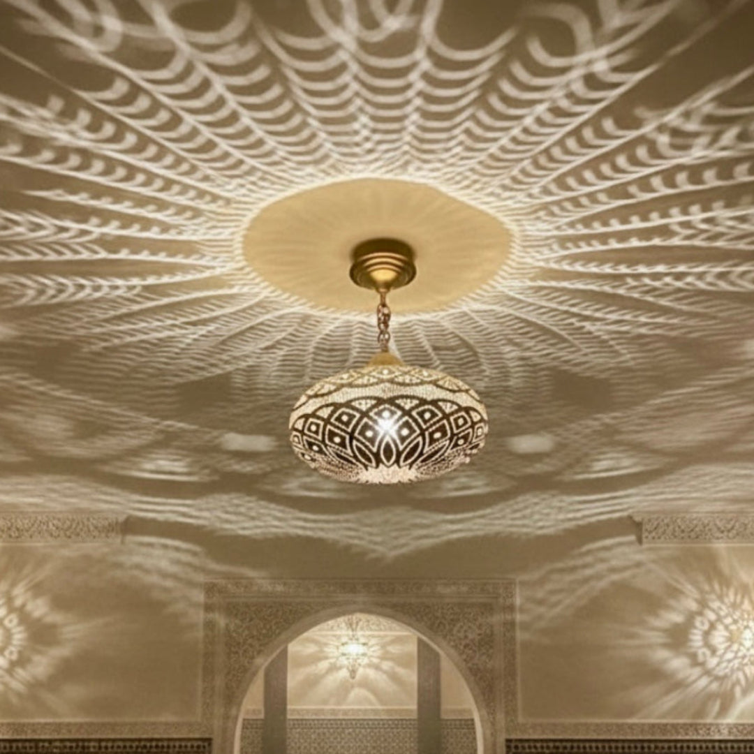 Traditional Moroccan brass lamp hanging in a luxury restaurant with mosaic tile walls and warm atmospheric lighting.