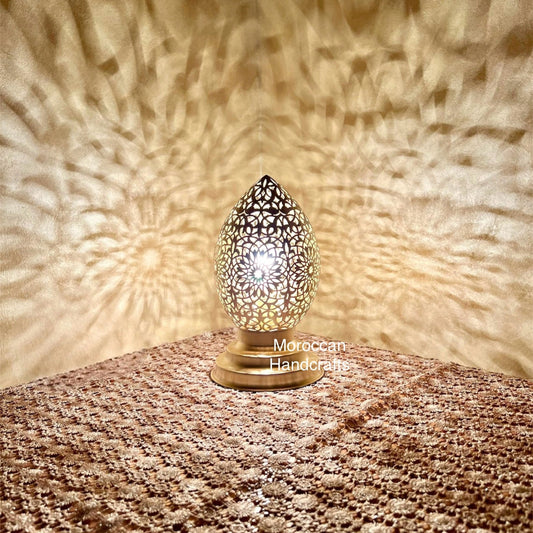 Handcrafted Moroccan egg-shaped lamp casting intricate star-like geometric shadow patterns on the wall.