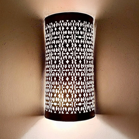 Exquisite outdoor Moroccan brass wall lamp casting beautiful shadow patterns on a stucco wall at dusk.