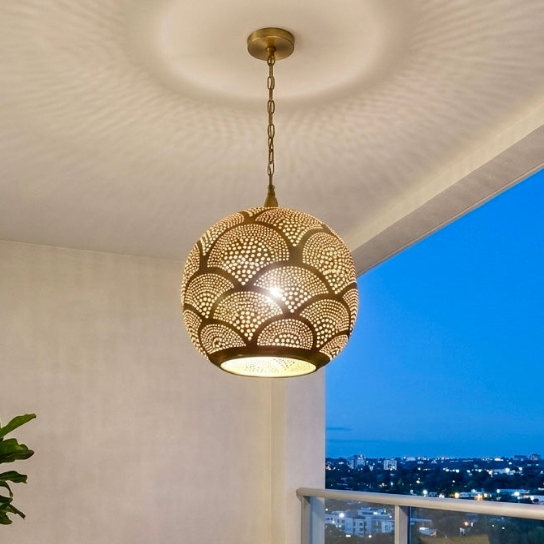 Luxury apartment balcony with a city view at dusk, decorated with a Moroccan brass pendant light that creates a magical ambiance on the terrace walls.