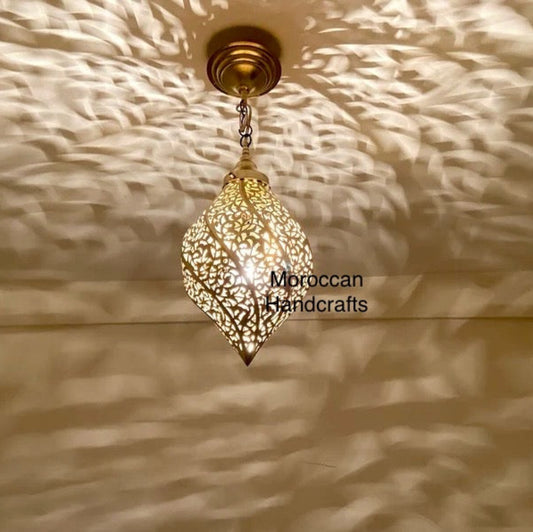 Handcrafted Moroccan brass pendant light in a tear drop shape, featuring an intricate leaf pattern that casts dramatic shadows.