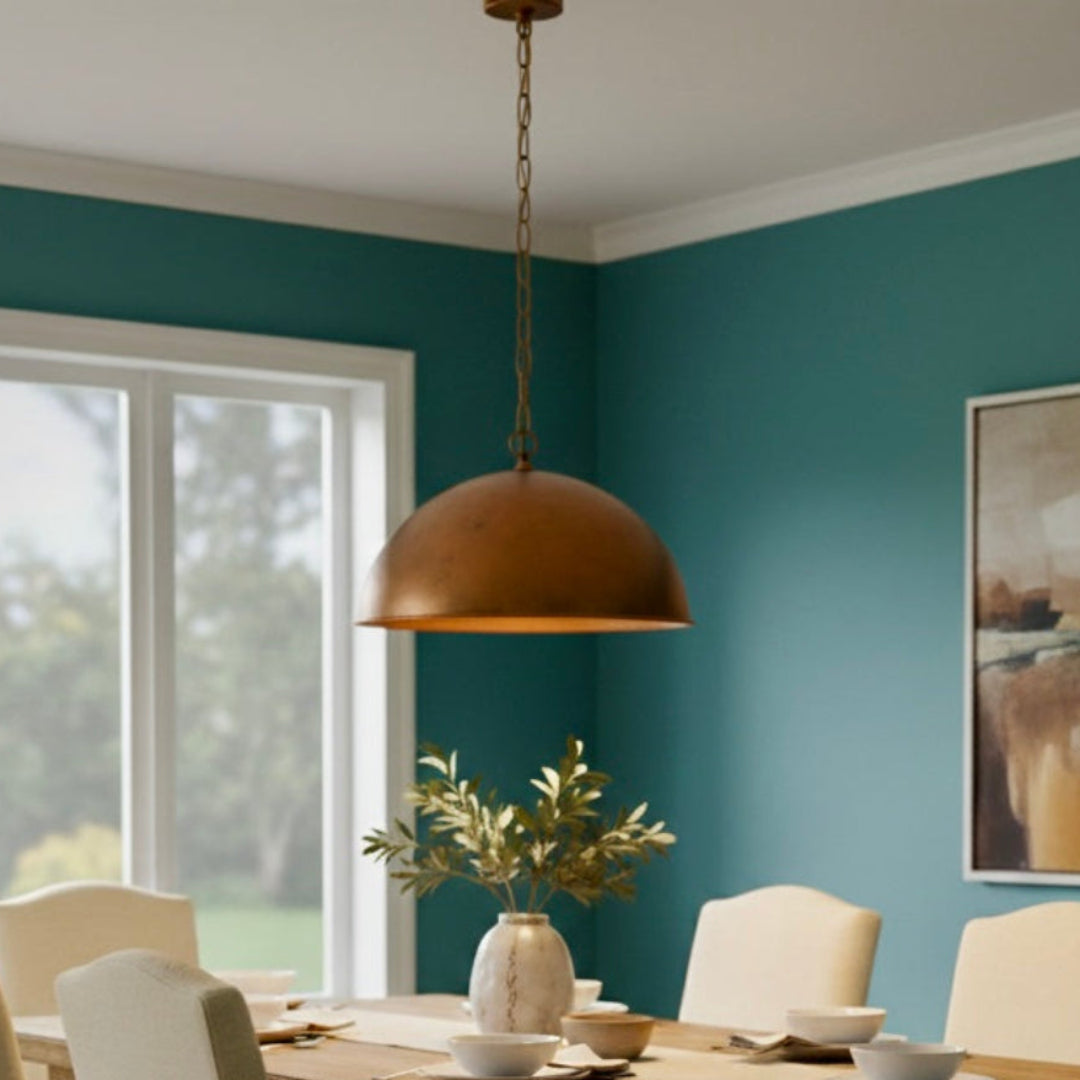 Warm copper dome ceiling light illuminating a cozy dining area with a neutral aesthetic and large window view.